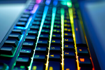 Keyboard with RGB light. Game keyboard with backlight, blurred background. Colorful gaming devices