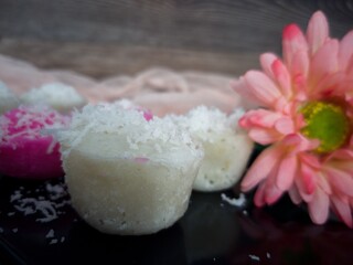 Fluffy and delicious steamed rice cake or locally known as apam beras or apam nasi with grated coconut on top. Selective focus points. Blurred background