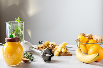 Peeled ginger root and rind. Kitchen knife and blender.