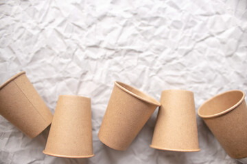 disposable kraft paper cups laid out on gray crumpled paper