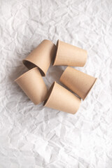 disposable kraft paper cups laid out on gray crumpled paper
