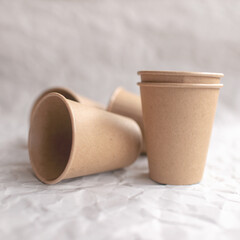 disposable kraft paper cups laid out on gray crumpled paper