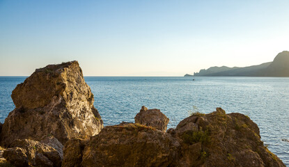Fototapeta na wymiar Rocks, slight sea waves at sunset on a warm summer evening.