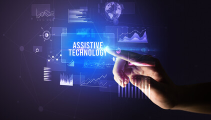 Hand touching ASSISTIVE TECHNOLOGY inscription, new business technology concept