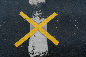 Fototapeta na wymiar Yellow road mark cross like an x ​​with white line on the road, no person, vertical format, space for text