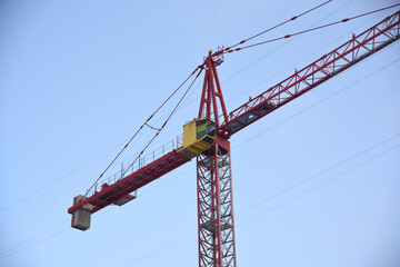 Construction crane with yellow booth on sky background