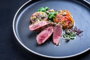 Modern style traditional wild hare back filet braised with tomato slices and capers in herb jus...