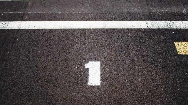 Motor sport background, panning on number 1 on asphalt track and checkered starting line pole position