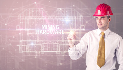 Handsome architect with helmet drawing MINING HARDWARE inscription, new technology concept