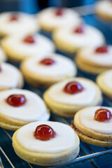 Shortbread biscuits with white icing and a cherry
