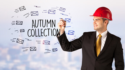 Handsome businessman with helmet drawing AUTUMN COLLECTION inscription, contruction sale concept