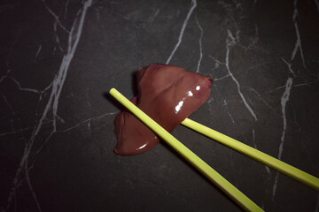 raw chicken liver with yellow chopsticks