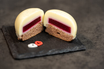 vanilla moose cake cut in half in the shape of a heart on ardesia