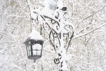 winter city park, lantern covered in the snow and snowfall