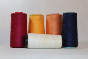 colored thread cones on white background