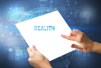 Hand holdig futuristic tablet with REALITY inscription, new technology concept