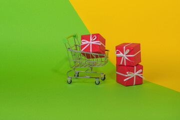 Minimal concept idea made of shopping cart full of gift box on green and illuminating yellow and...