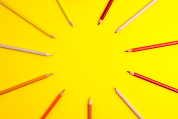 Wooden pencils of red orange an colors on yellow background. Flat lay top view. Education template back to school and online study concept with copy space