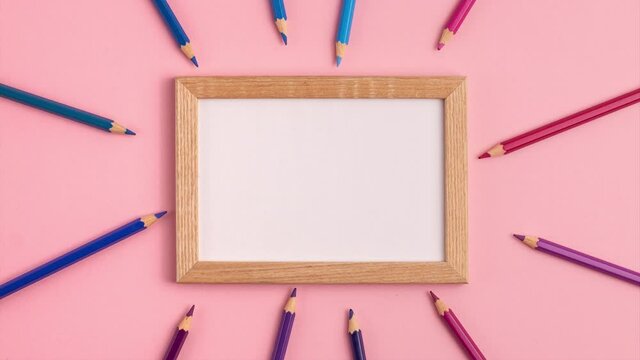Stop motion animation mockup of wooden frame and pencils around it on pink background. Flat lay top view. Education template back to school and online study concept with copy space