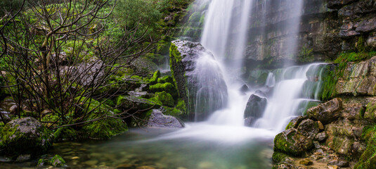 Fototapeta premium Beautiful waterfall in the mountains of Serra de Aire, Portugal. Long exposure of the waterfall of Fornea in Porto de Mos, Portugal. 