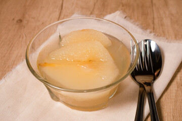 Fresh half Pears Served with sweet syrup. Wooden table background.