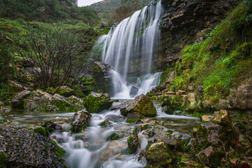 Fototapeta premium Beautiful waterfall in the mountains of Serra de Aire, Portugal. Long exposure of the waterfall of Fornea in Porto de Mos, Portugal. 