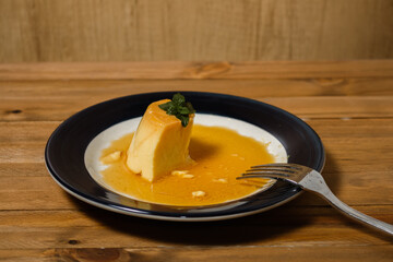 Eating the delicious typical Argentine and South American dessert called Flan with caramel. The diner's hand is observed. Natural and healthy eating concept.