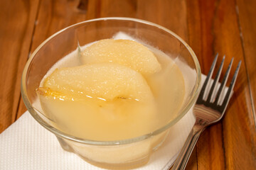 Fresh half Pears Served with sweet syrup. Wooden table background.