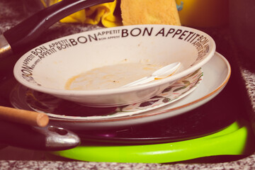 Set of dirty dishes, cutlery and pans in the sink ready to be washed. Domestic hygiene concept.