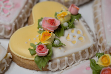 Obraz na płótnie Canvas Romantic heart cookies decorated with royal icing roses, yellow and pink