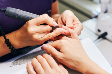 Closeup image of nail cuticle manicure treatment with electric machine