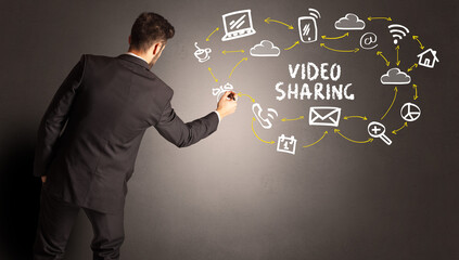 businessman drawing social media icons with VIDEO SHARING inscription, new media concept