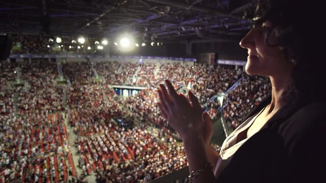 Hispanic woman applause, clap hands at business meeting in arena hall