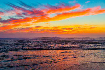 Obraz premium Sea landscape on sunset or sunrise with ocean waves and orange colorful clouds in sky. Concept of vacation on beach, free time, travel, summer, disconnecting from routine and relaxing.