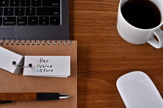 On the desk there is a laptop, a cup of coffee, and a word book with the word KVS written on it. It was an abbreviation for the financial term key value store.