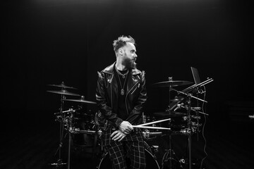 brutal portrait of a man musician with a beard and in black clothes on the background of musical...