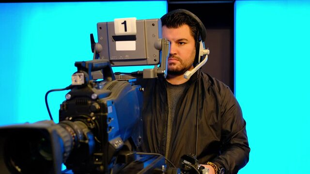 Professional cameraman with headphones with HD camcorder in live television	