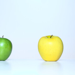 green and yellow apples on a white kitchen table