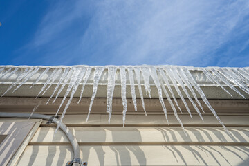 gutters have frozen and icicles hang from the ice dams