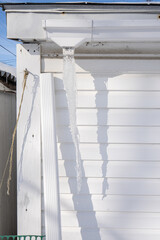 gutters have frozen and icicles hang from the ice dams