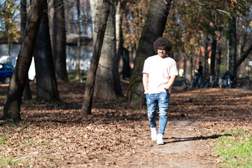 Naklejka na ściany i meble Young Man Walking in Autumn Forest