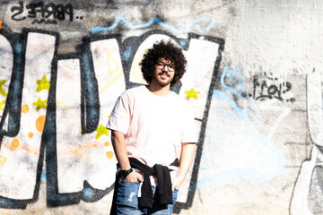 Naklejka na ściany i meble Trendy Handsome Man Posing at Graffiti Wall Outside