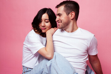 young cheerful caucasian couple together having fun on pink background, guy ang girl modern relationship, lifestyle people concept