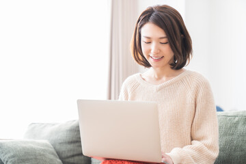Naklejka premium 部屋でラップトップコンピューターを見る女性