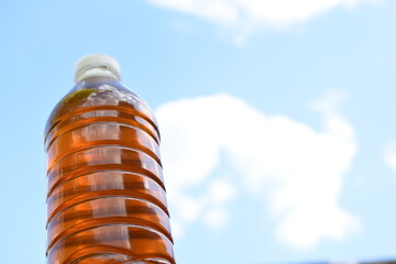 Botella de miel de abeja natural sobre cielo azul