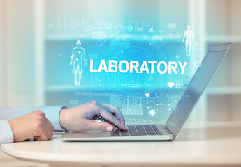 Doctor working a health check with LABORATORY inscription, recording medical test results