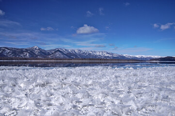 冬の湖のフロストフラワーと白銀の山脈。北海道の屈斜路湖。