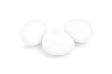 Tres huevos blancos sobre fondo blanco