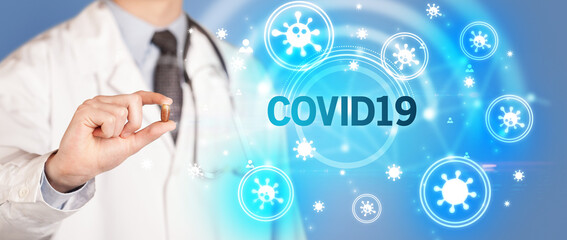 Doctor giving pill with COVID19 inscription, coronavirus concept
