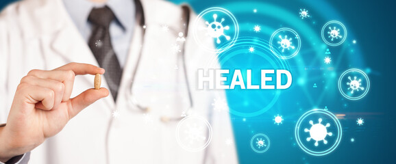 Doctor giving pill with HEALED inscription, coronavirus concept